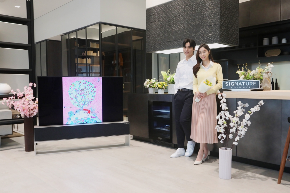 LG전자가 超(초)프리미엄 빌트인 가전 브랜드 ‘시그니처 키친 스위트(SIGNATURE KITCHEN SUITE)’ 청담 쇼룸에서 봄맞이 특별 전시회를 연다. 모델들이 LG 시그니처 올레드 R(왼쪽 첫 번째)에서 보여주는 NFT 기반 이왈종 작가의 미술 작품 ‘제주생활의 중도’와 컬럼형 와인셀러 등 시그니처 키친 스위트 제품이 전시된 청담 쇼룸 3층 리빙관을 소개하고 있다.