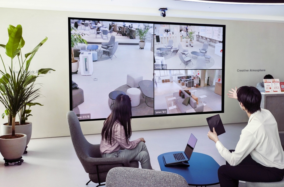 SK텔레콤 홍보모델이 거점오피스 ‘Sphere’ 신도림에 설치된 대형 미디어월 ‘스피어비전’을 통해 다른 거점오피스와 소통하고 있는 모습. [사진=SK텔레콤]
