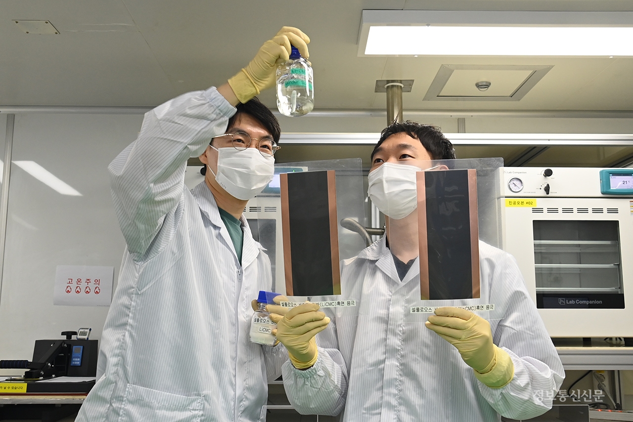 연구진이 전도성 셀룰로오스 바인더 소재와 전고체 이차전지 음극판을 관찰하고 있다. [사진=ETRI]