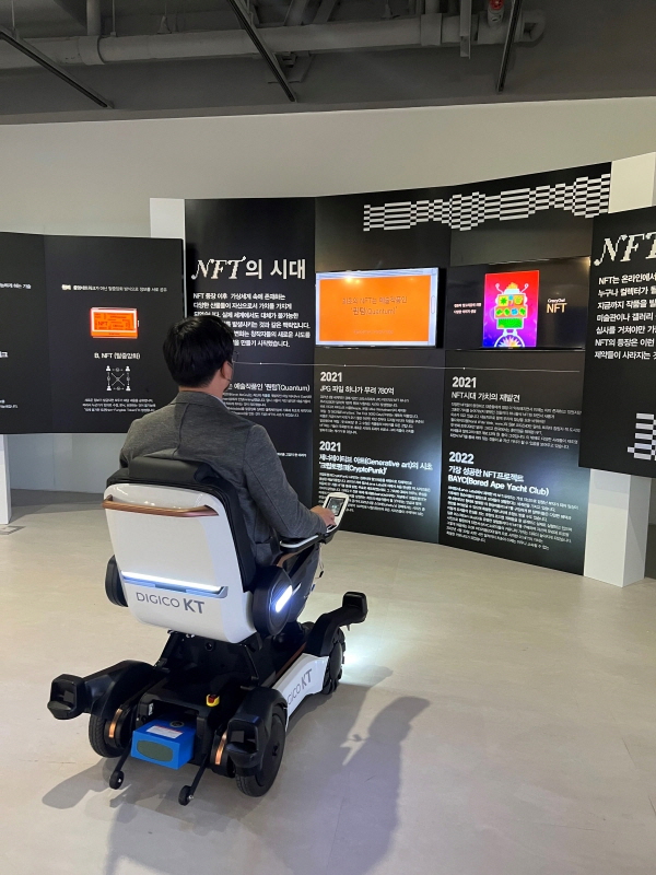 KT가 서울디자인재단과 함께 서울 중구 동대문디자인플라자에서 전시 관람들을 대상으로 ‘자율주행 스마트로봇체어’를 시범 운영한다고 밝혔다. 동대문디자인플라자에서 KT 자율주행 스마트로봇체어를 이용해 전시물을 관람하는 모습. [사진=KT]