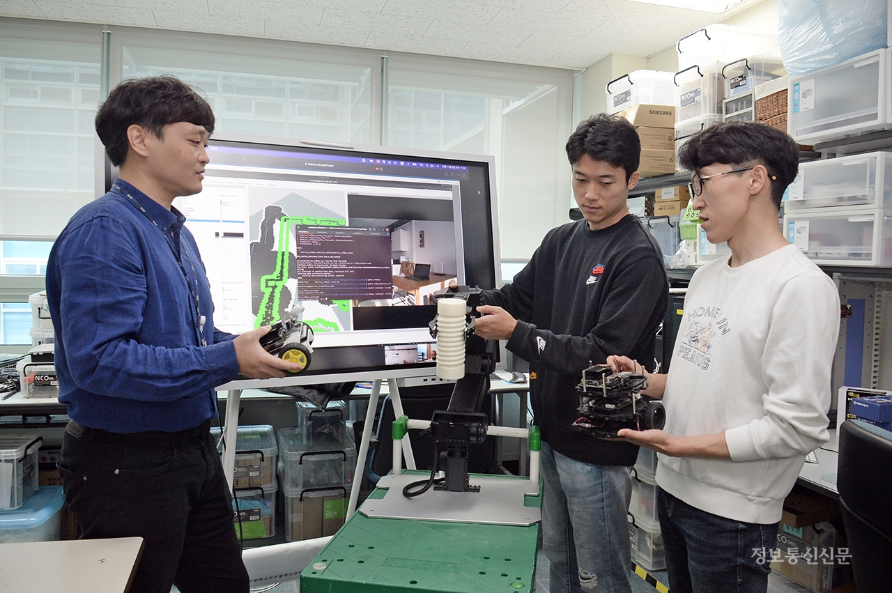 연구진이 '액션브레인' 기술이 적용된 보조 로봇의 행동 인식에 대해 논의하는 모습. [사진=ETRI]