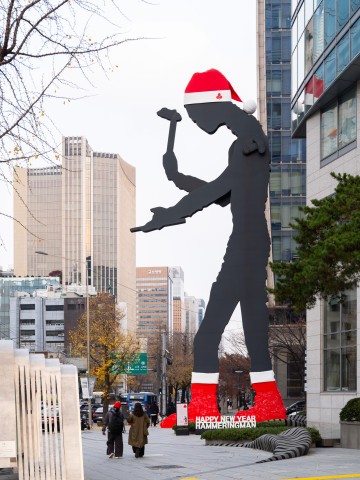 서울 광화문 랜드마크 ‘해머링 맨’이 사랑의열매 산타 모자를 쓰고 빨간 양말을 착용했다.