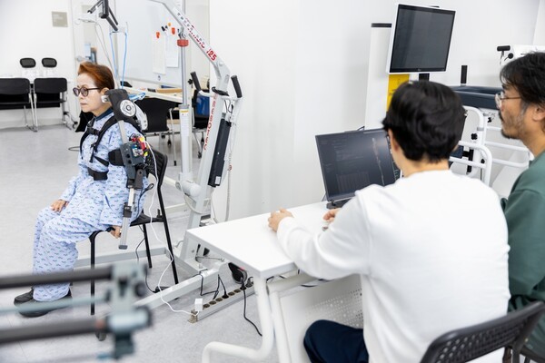 연구진이 환자가 직접 웨어러블 로봇을 착용하고 움직이는 상태에서 측정되는 데이터를 분석하고 있다. [사진=ETRI]